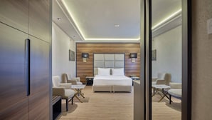 Une chambre d’hôtel moderne avec un grand lit, deux tables de chevet, un bureau et une chaise.