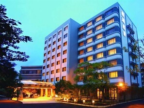 A multi-story hotel with a modern design, featuring a prominent entrance with a covered area and a well-lit facade.