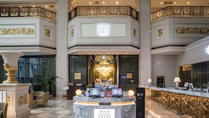 A lobby with a marble reception desk labeled "Grand Table Buffet," a chandelier, and a check-in counter. - High1 Grand Hotel Main Tower (Jeongseon)