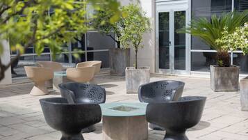 Espace extérieur aménagé avec des jardinières et une table en verre.
