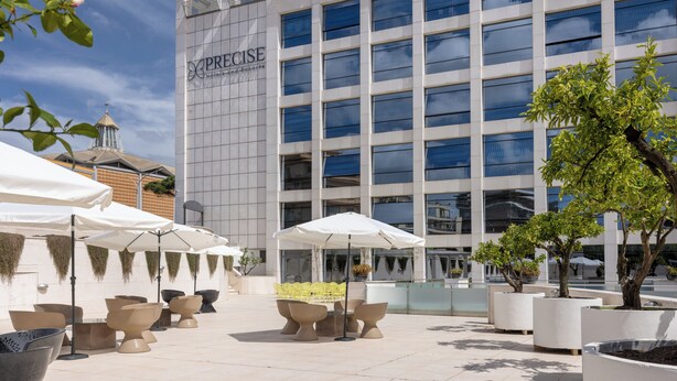 Un hotel con terraza al aire libre y fachada de edificio moderna.