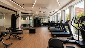 A gym with treadmills, exercise equipment, and large windows. - Precise House Mantegna Roma (Rome)