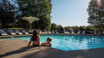 Una piscina con sillas de descanso y sombrillas.