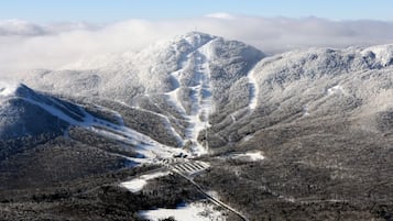 A snow-covered mountain with a ski resort at its base, including ski runs and a lodge.