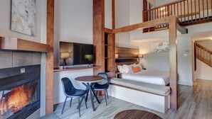 Una habitación moderna, de varios niveles, con chimenea, comedor y cama.