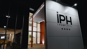 Exterior do Hotel iPoint com design moderno, grandes janelas de vidro e entrada visível.