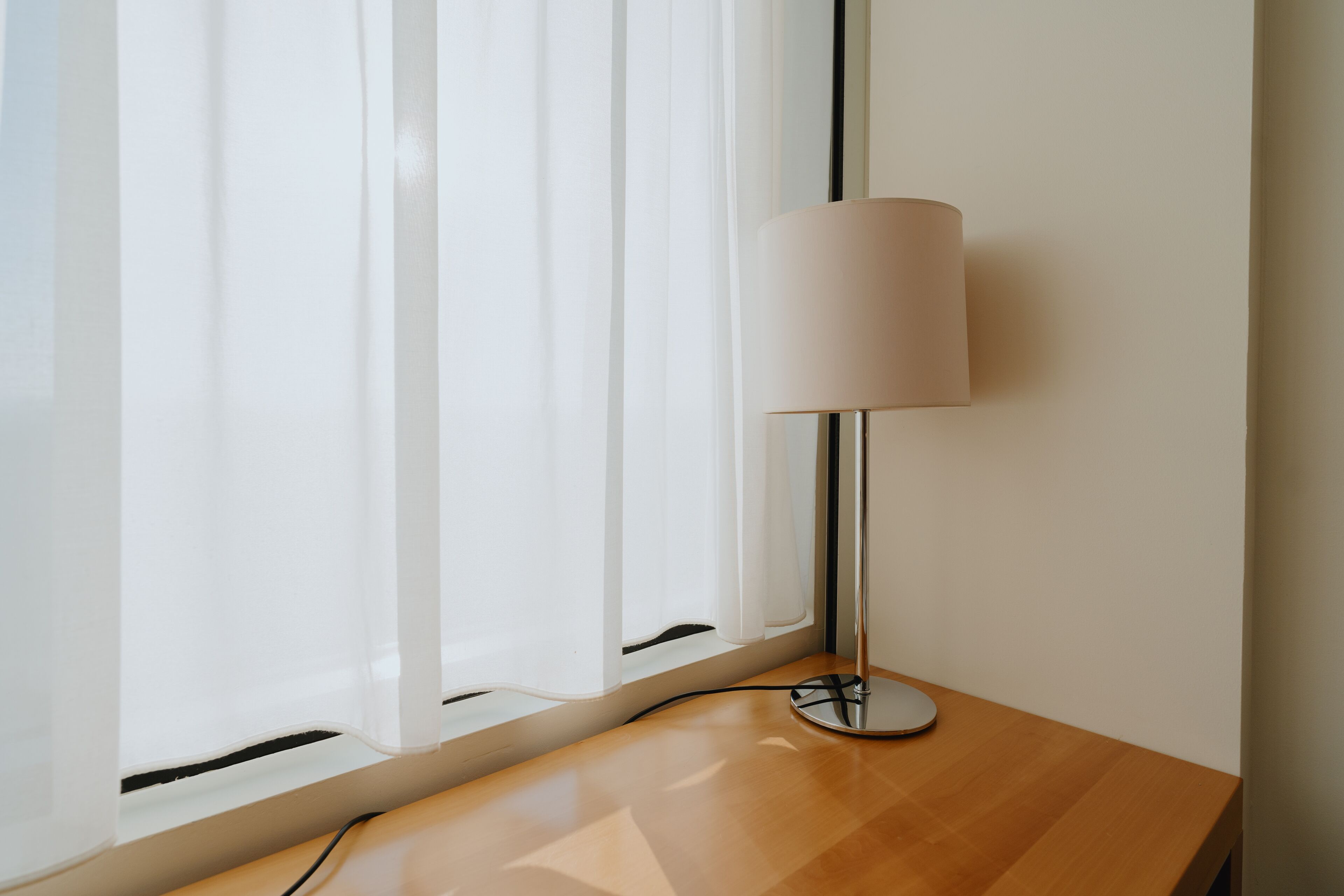 Ein Holztisch mit Lampe und Stromkabel.