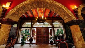 An arched entrance with a wooden door, stone columns, and a chandelier. - Hotel Posada de Vallina by MiRa (Córdoba)