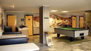 A reception area with a pool table, a reception desk, and a seating area. - Hotel Heidenschanze (Dresden)