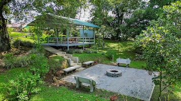 A garden with a gazebo, a fire pit, and outdoor seating.