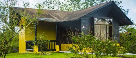 A two-story house with a dark roof and yellow siding.