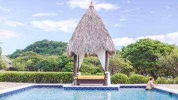 Una piscina al aire libre, sillones reclinables de piscina