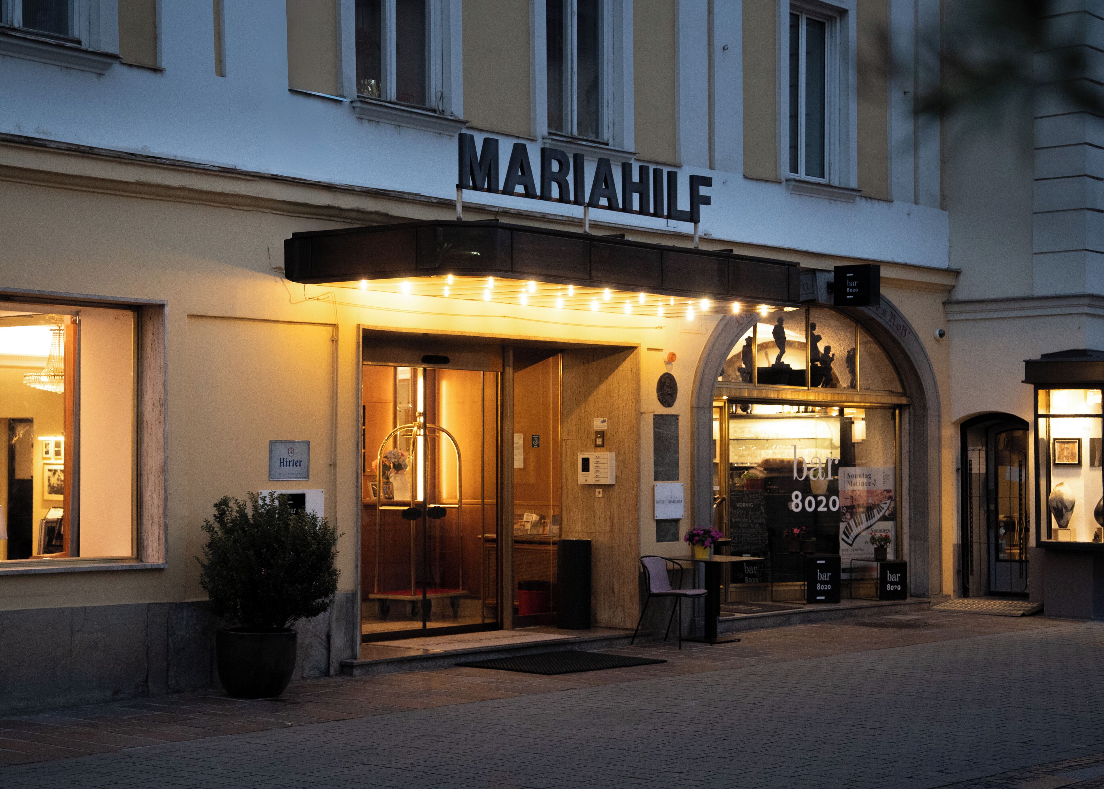 Un edificio con un letrero que dice "MARIAHILF" y un bar llamado "bar 8020" en su interior.