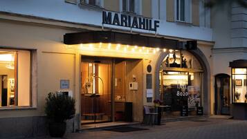 Ein Gebäude mit einem Schild mit der Aufschrift 'MARIAHILF' und einer Bar namens 'bar 8020' im Inneren.