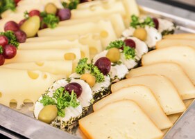 A variety of cheeses and olives arranged on a tray.