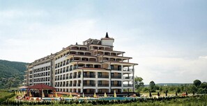 Ein mehrstöckiges Hotel mit Balkonen, einem Schwimmbecken und Außenbereich.