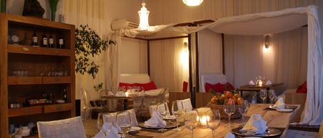 Un comedor con una mesa de madera dispuesta para una comida, rodeado de sillas.