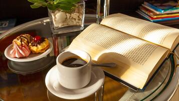 Een tafel met een boek, een kop koffie en een bord eten.