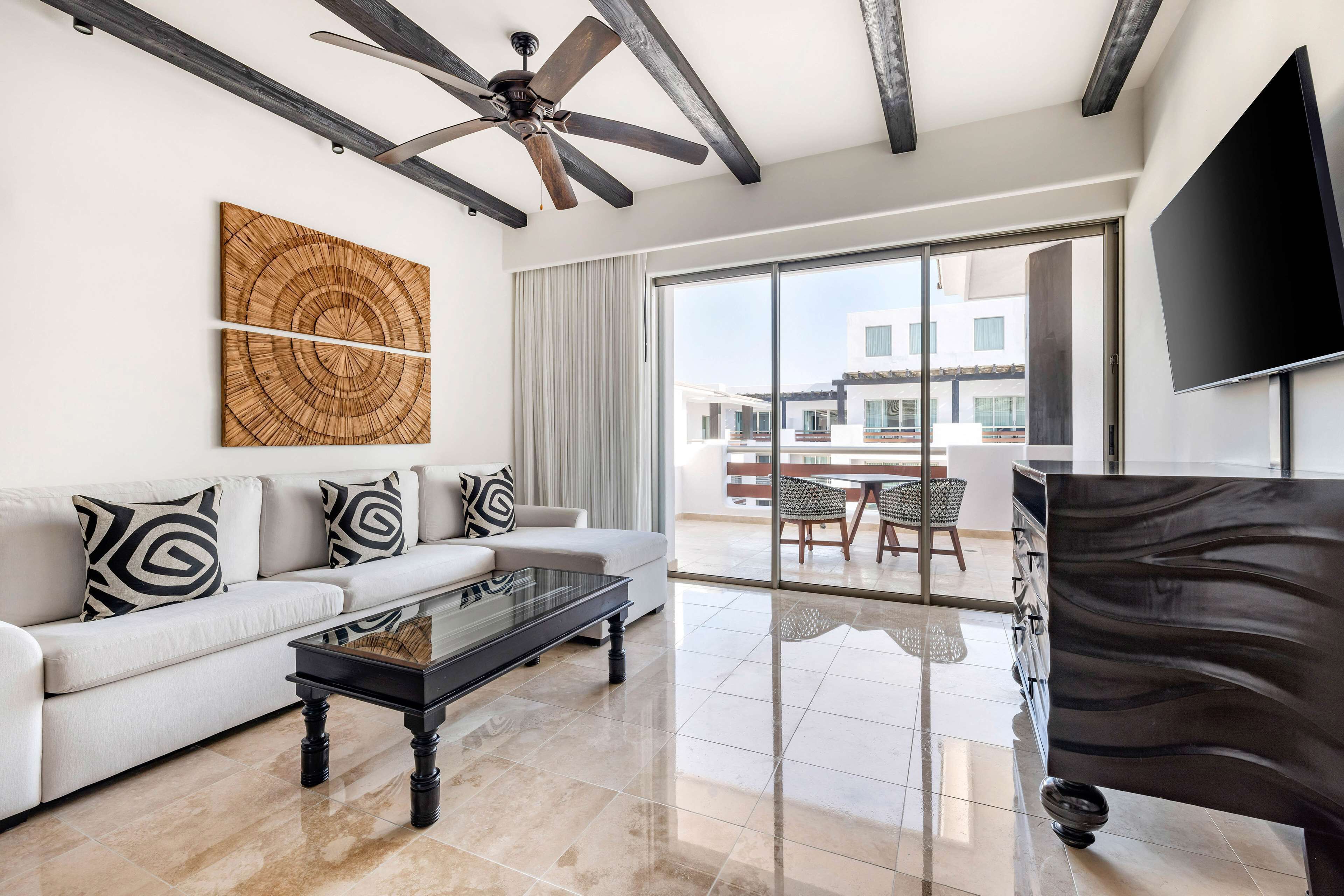 A modern living room with a sofa, coffee table, and a ceiling fan.