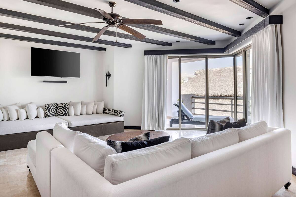 A modern living room with a sofa, a coffee table, and a ceiling fan.