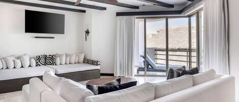 A modern living room with a sofa, a coffee table, and a ceiling fan.