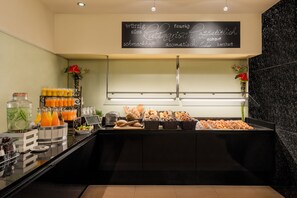 A buffet area with a variety of food items and beverages.