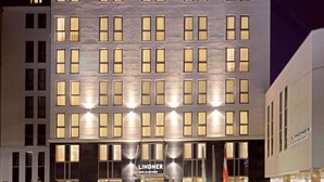 A modern hotel with a symmetrical facade, multiple windows, and a prominent entrance with the name 'Lindner' displayed. - Lindner Hotel Vienna Am Belvedere, part of JdV by Hyatt (Vienna)