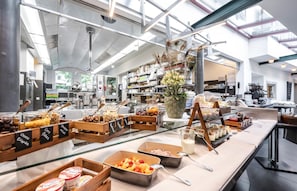 A buffet area with various food options and a modern kitchen in the background. - Hotel Hofgarten (Lucerne)