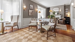 A dining area with a round table, four chairs, a rug, and a fireplace with decorative items. - Isaiah Jones Homestead Bed & Breakfast (Sandwich)