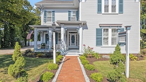 A two-story house with a brick pathway leading to the front door, surrounded by well-maintained gardens and a small porch. - Isaiah Jones Homestead Bed & Breakfast (Sandwich)