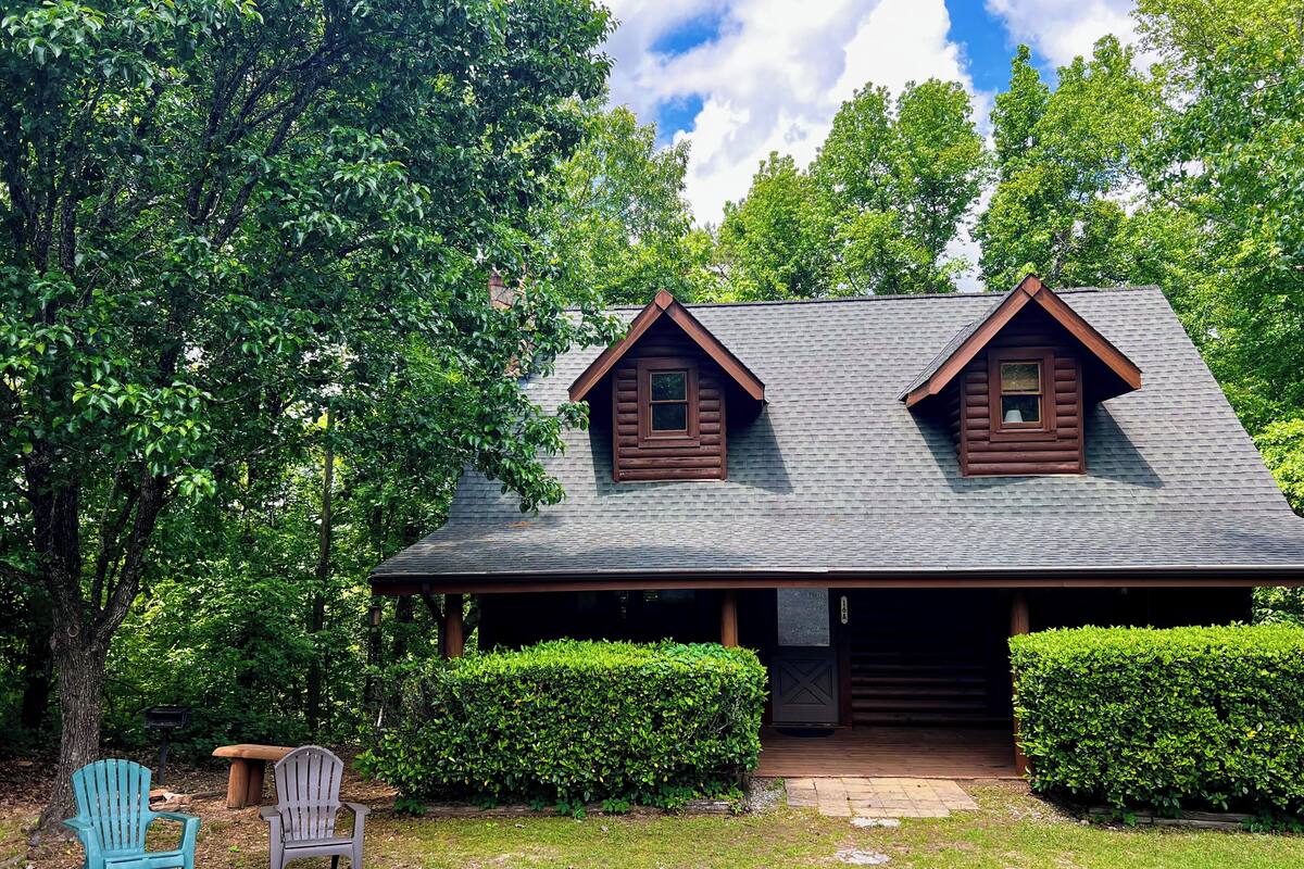 A cabin with a porch, two windows, and a covered entrance.