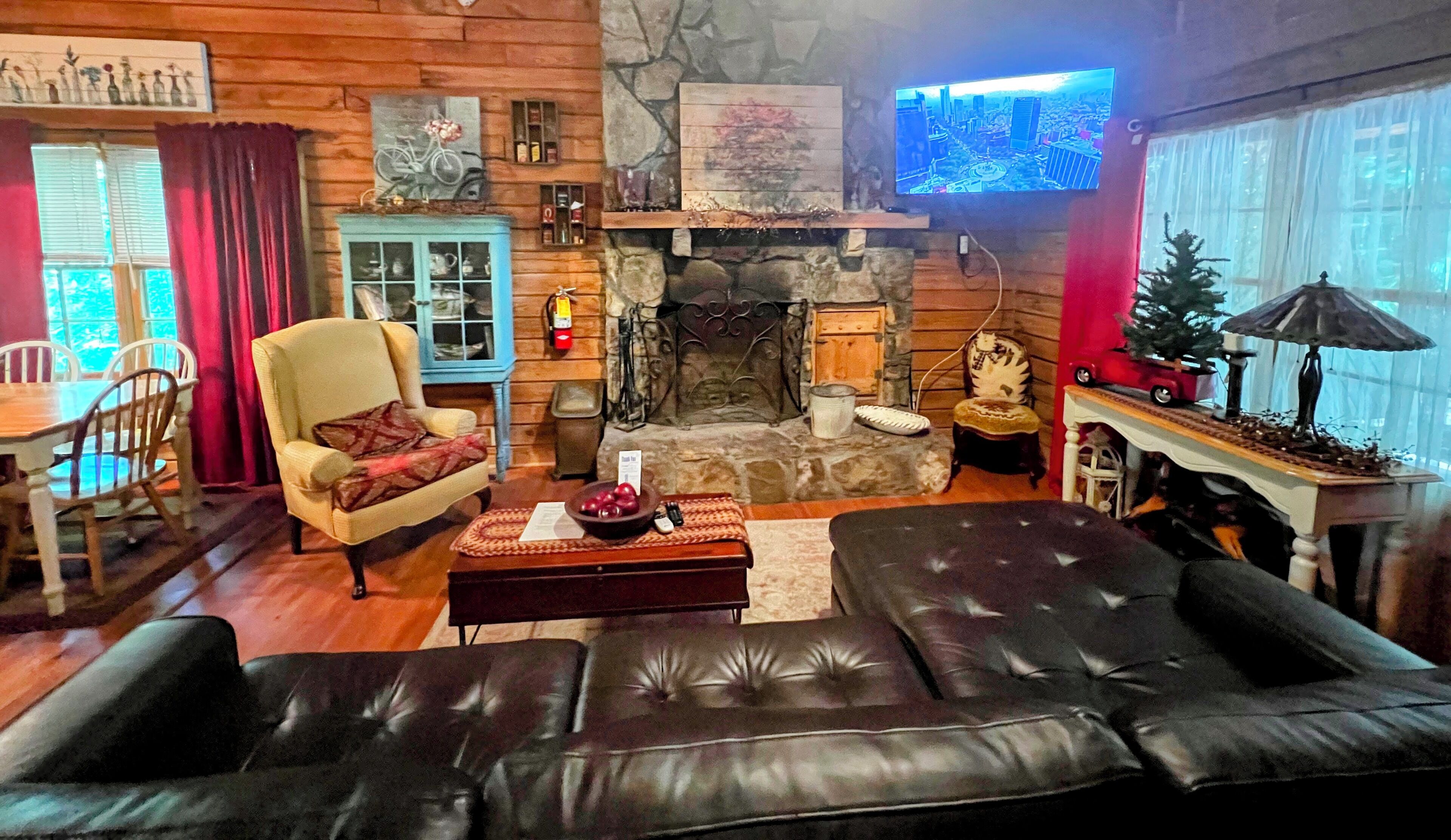 Una sala de estar acogedora con chimenea de piedra, un televisor montado en la pared y un comedor con muebles de madera.