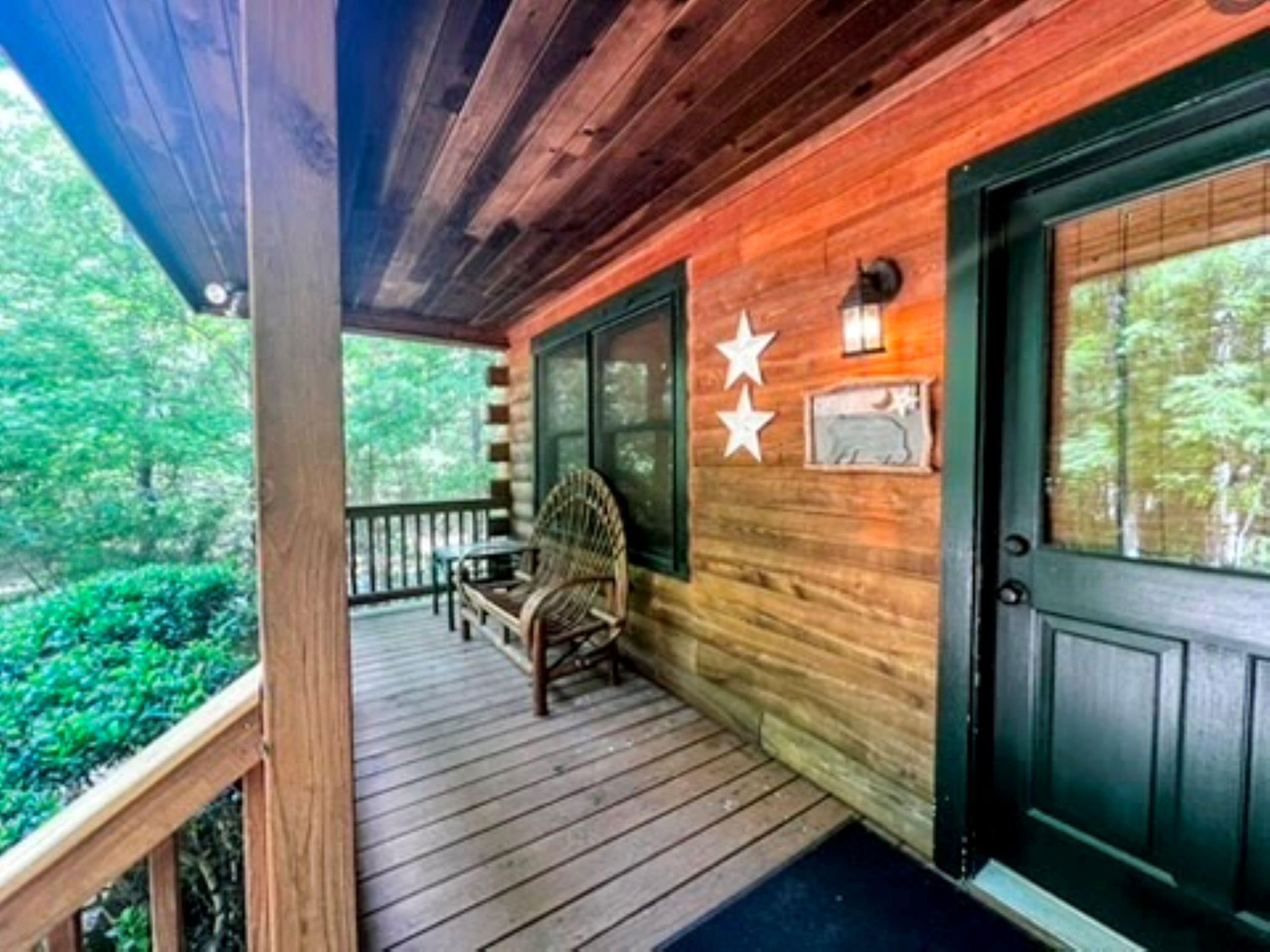 A wooden porch with a bench, a door, and a star decoration.