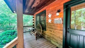 A wooden porch with a bench, a door, and a star decoration.