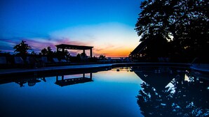 A serene pool area with lounge chairs and a gazebo at sunset. - Mountain Top Inn and Resort (Warm Springs)