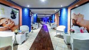 A hotel corridor with a central walkway, white wicker furniture, and large posters on the walls. - Hotel Rabat (Rabat)