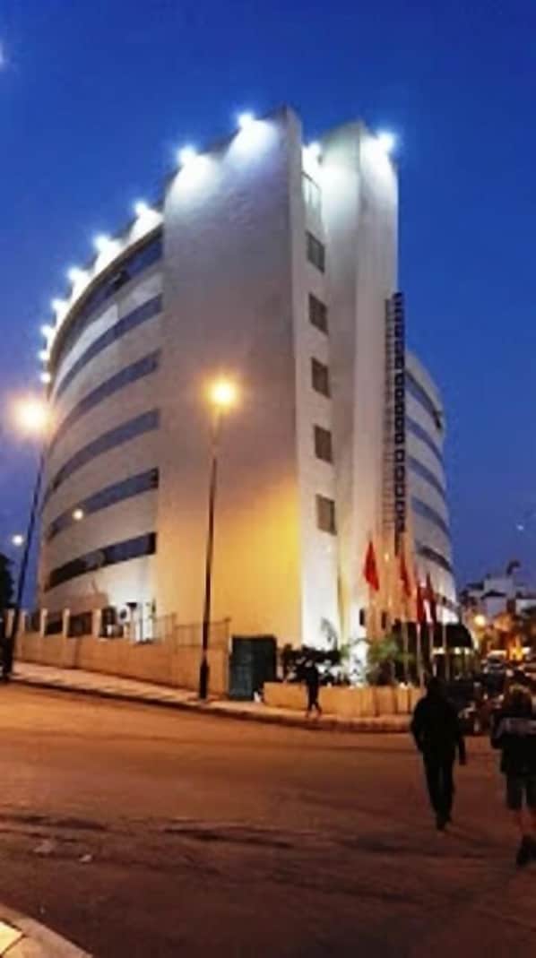 A large, multi-story building with a curved facade and multiple windows.