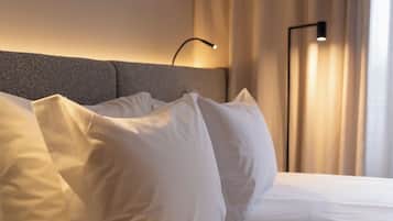 Una cama bien tendida con sábanas blancas y cabecera.