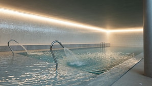 Een modern binnenzwembad met een strak design, helder water en een minimalistische uitstraling.