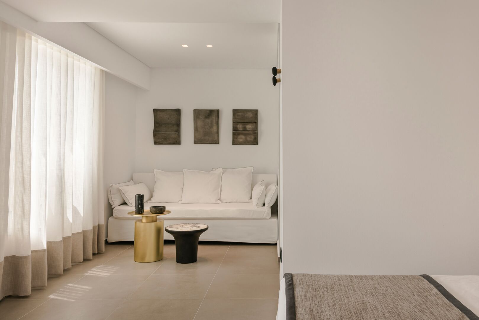A modern living room with a sofa, two side tables, and artwork on the wall.