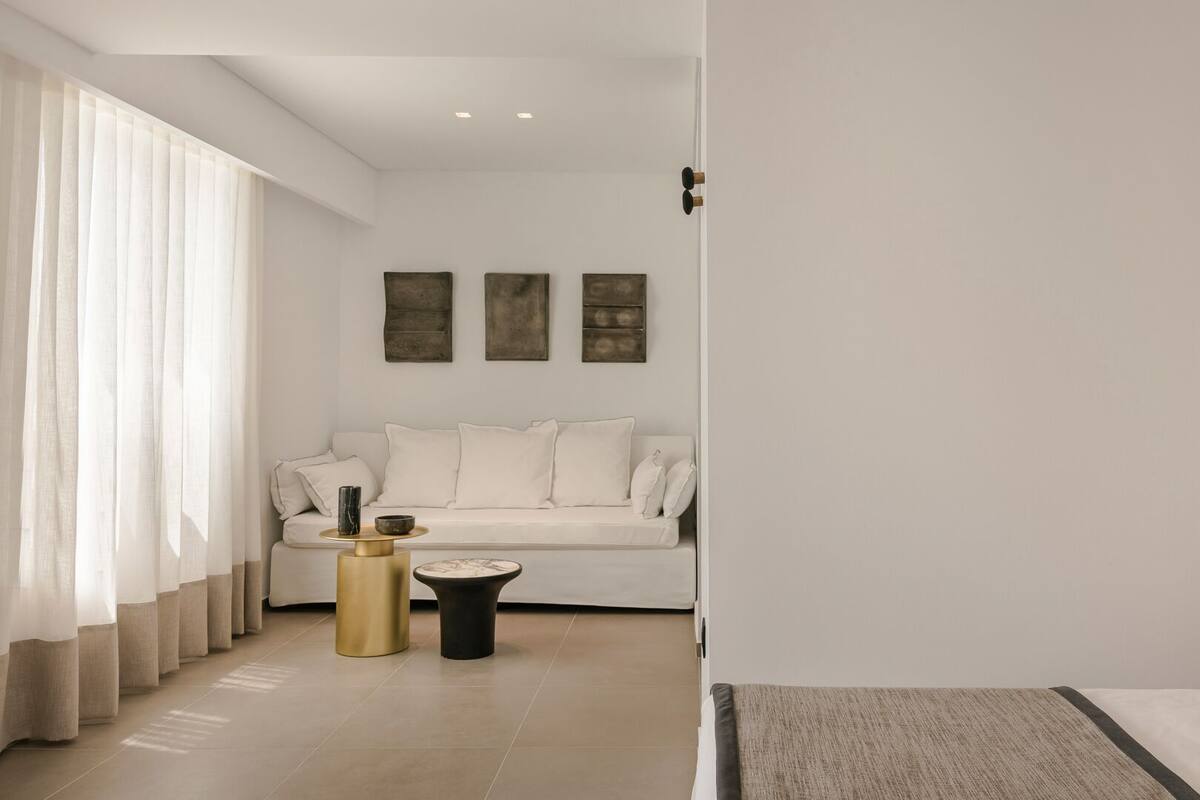 A modern living room with a sofa, two side tables, and artwork on the wall.