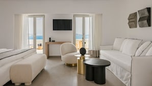 A modern hotel room with a bed, a sofa, a desk, and a TV. - Grace Mykonos (Mykonos)