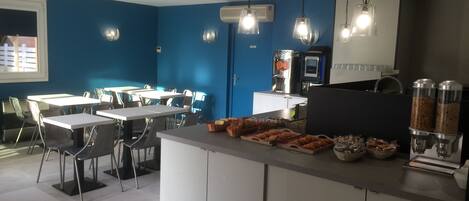 A modern kitchen with a blue accent wall, white cabinetry, and a central island with food items.