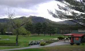A golf course with a clubhouse and a golf cart. - Jack O'Lantern Resort and Golf Course (North Woodstock)