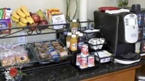 A breakfast bar with various food items and a coffee machine. - North Bay Inn (San Rafael)