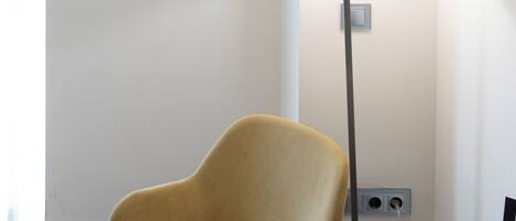 A room with a chair, a table, a lamp, and a box with text.