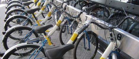 A row of bicycles parked at a bike rental station.