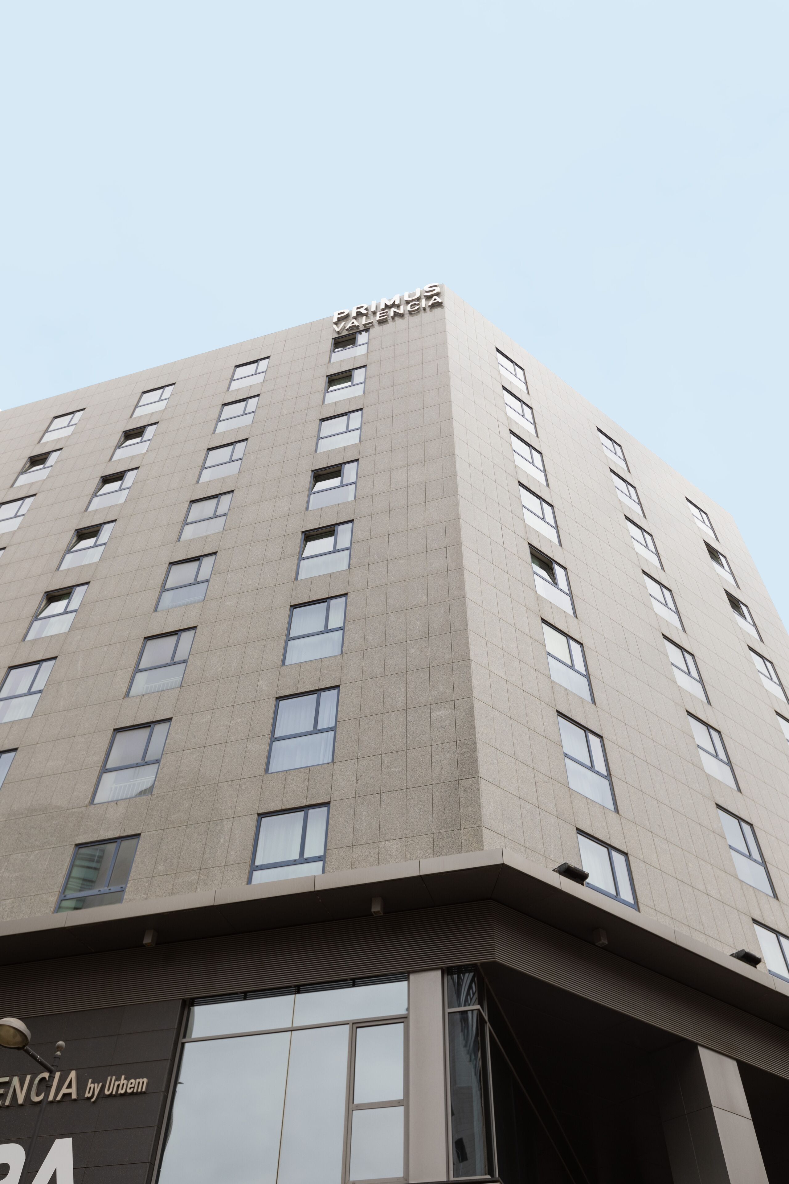 Un edificio de varios pisos con un diseño moderno, que destaca un letrero grande en la parte superior.