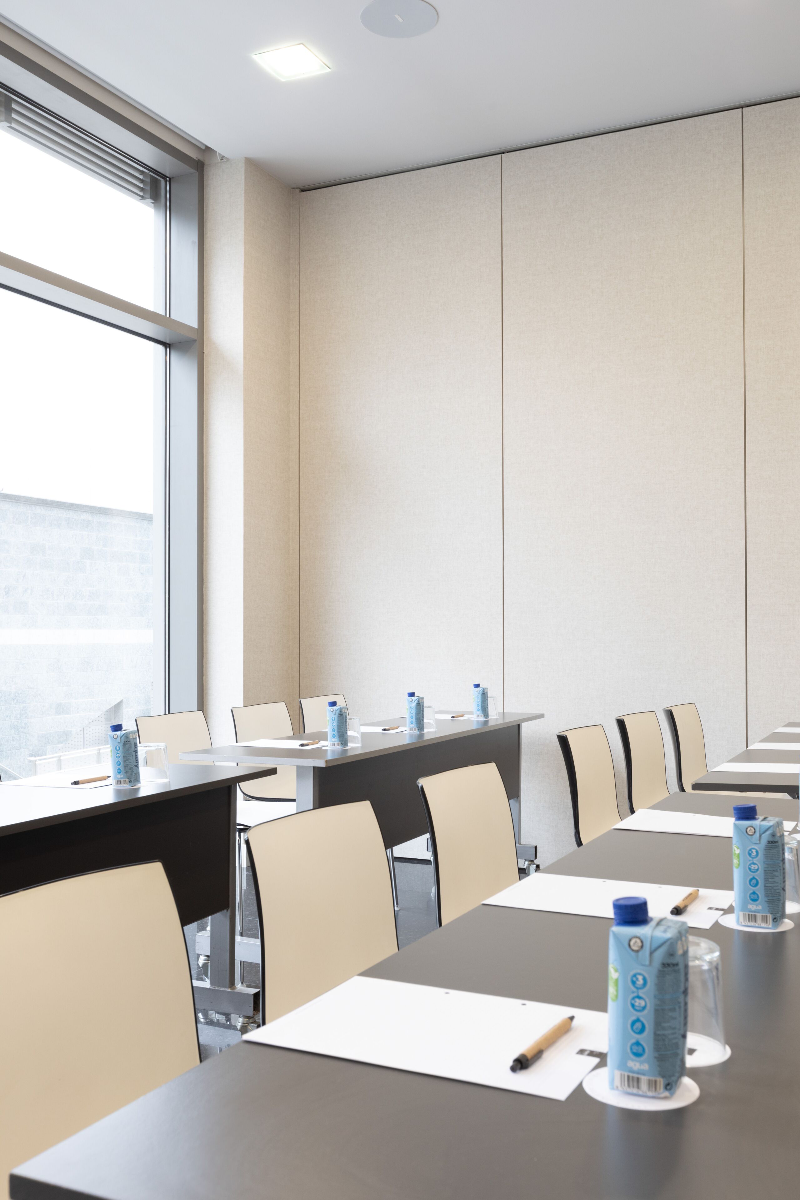 A conference room with a long table, chairs, and water bottles.