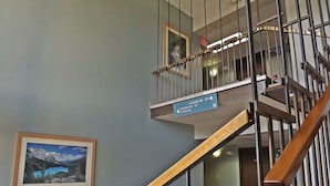 A staircase with a sign indicating directions to rooms and a framed picture on the wall. - Travelodge by Wyndham Kalispell (Kalispell)